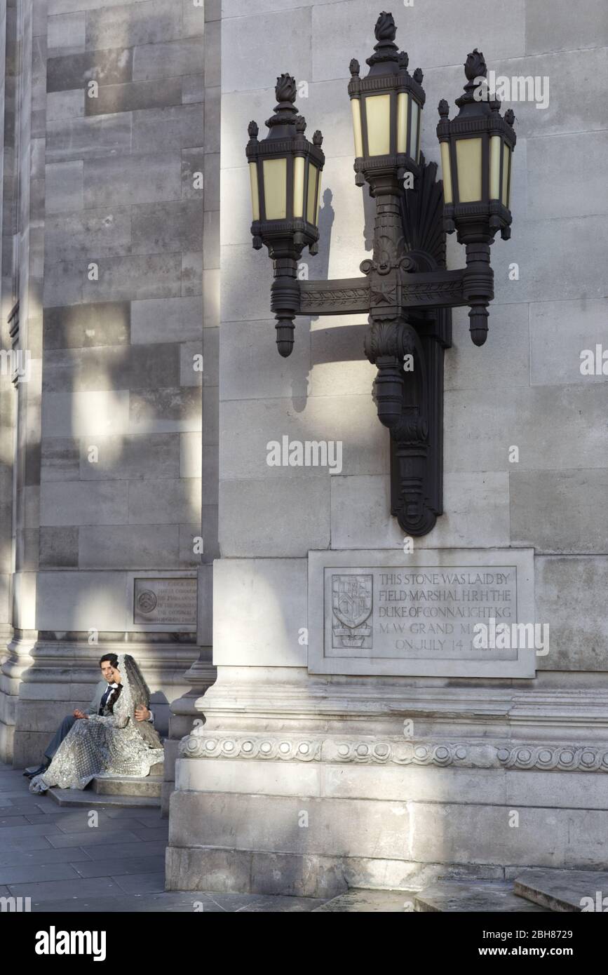 vintage decorative lamp and bride and groom on the steps at the Freemasons hall London Stock Photo