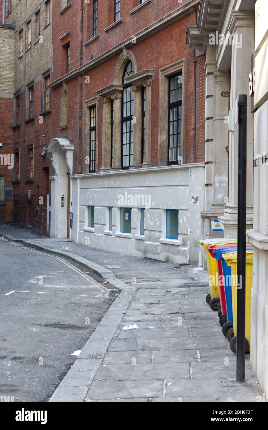 yellow textiles bin, red plastics bin and blue paper bin recycling bins on the empty streets  of London Stock Photo