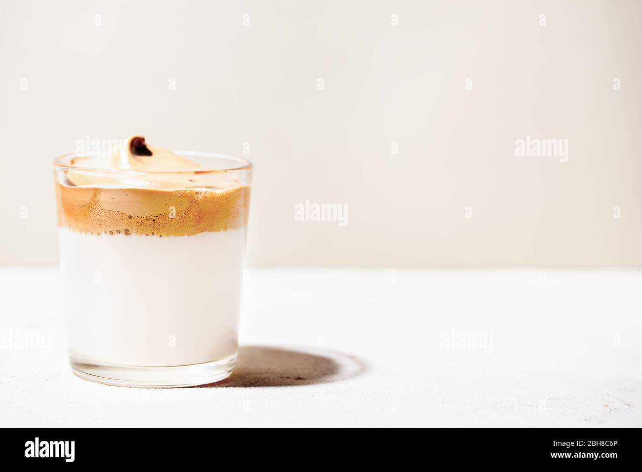 Trendy fluffy creamy whipped iced Dalgona coffee on white background