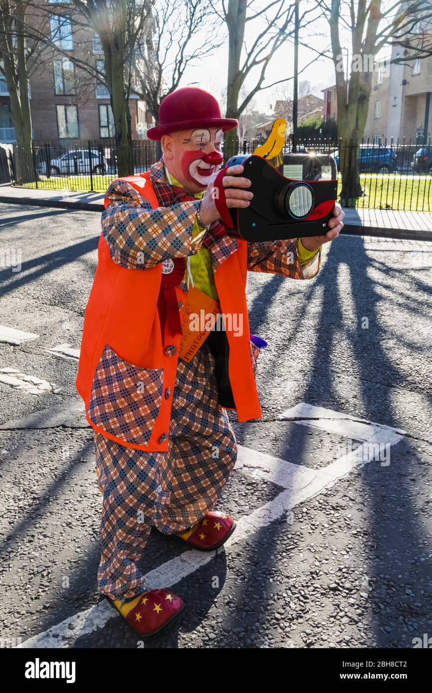 England, London, The Annual Grimaldi Clowns Church Service at All Saints Church, Haggerston, Clown with Toy Camera Stock Photo