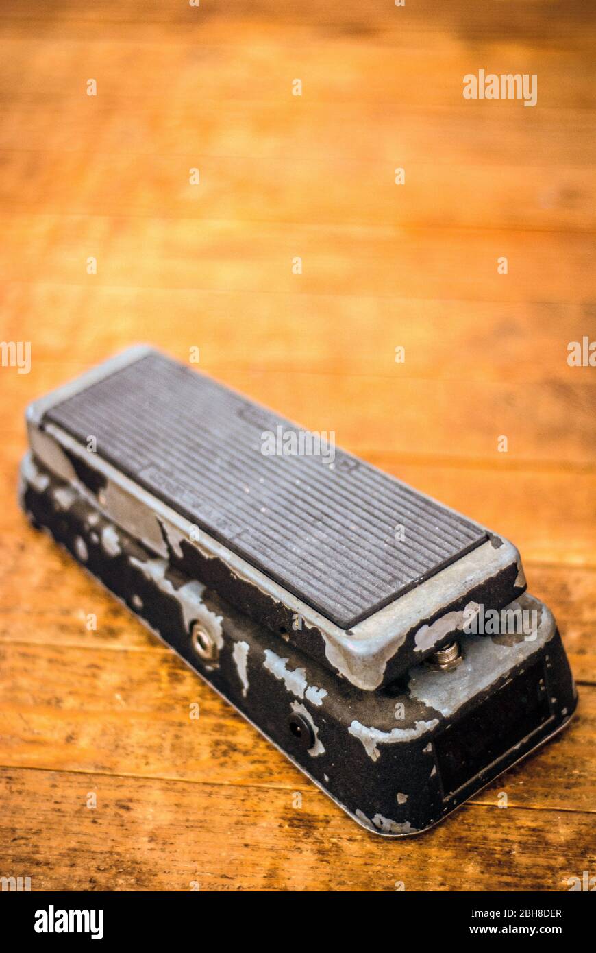 Vintage Wah Pedal on a Dirty Hard Wood Floor. Stock Photo