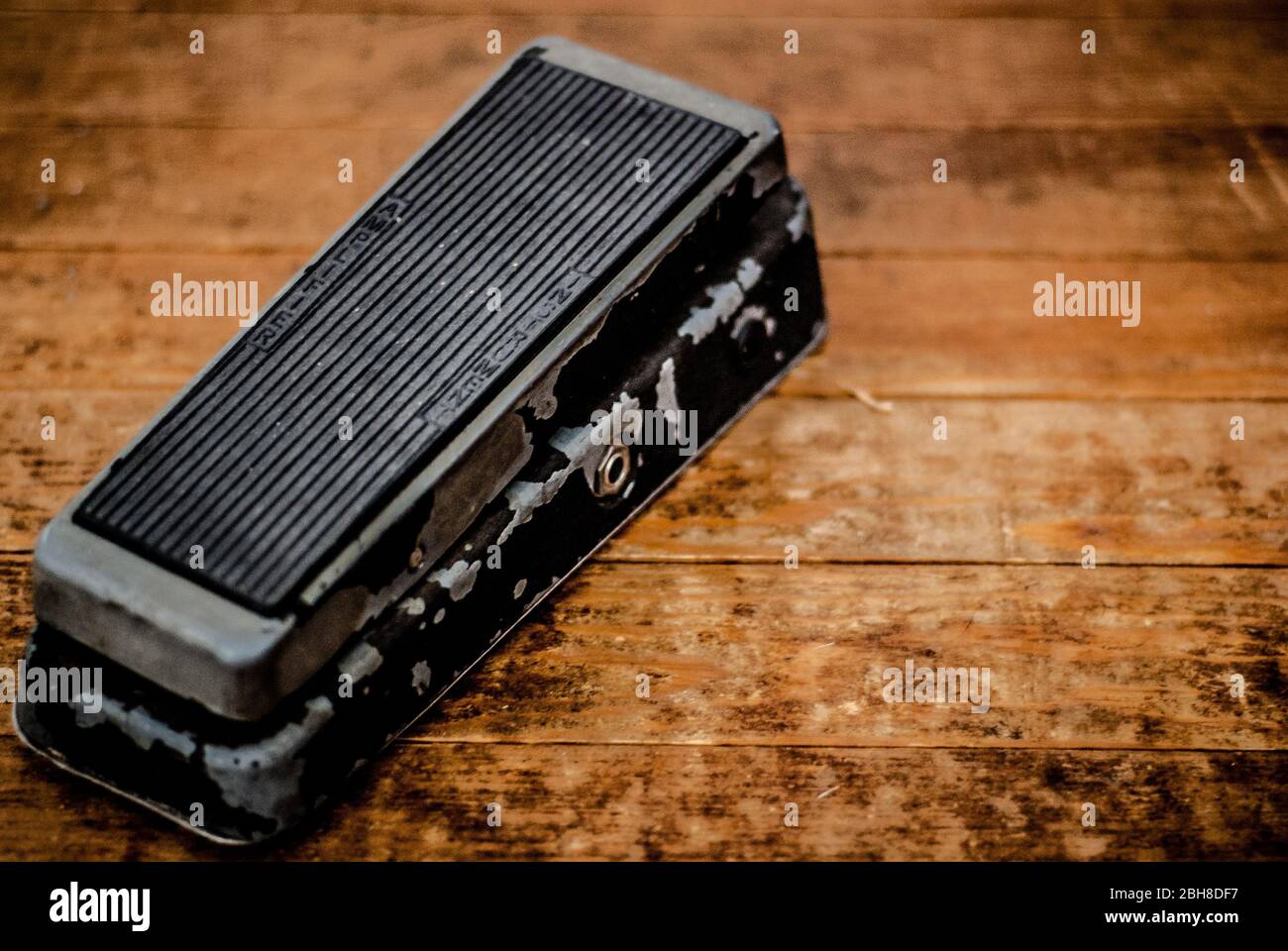 Vintage Wah Pedal on a Dirty Hard Wood Floor. Stock Photo