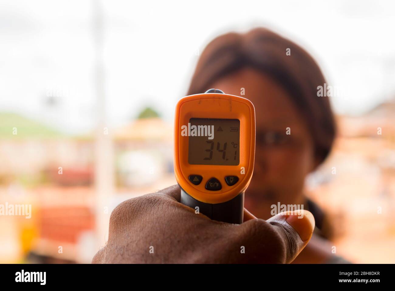 Close-up shot of a young african woman using infrared forehead ...