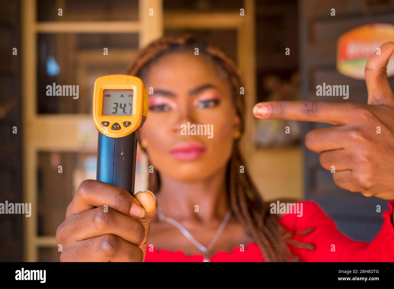 Close-up shot of a young african woman holding infrared forehead ...