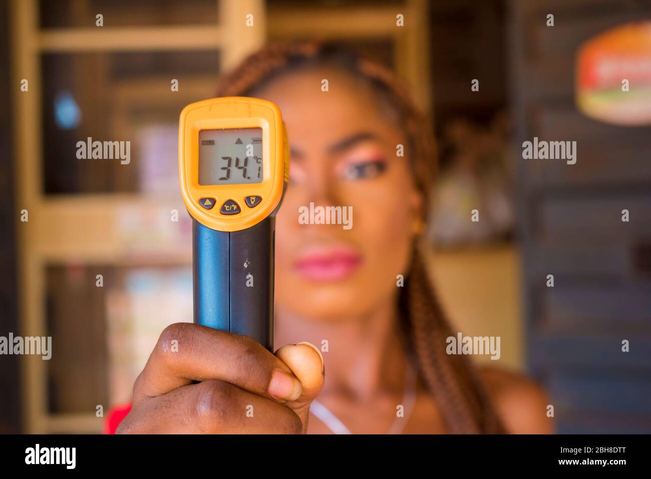 Close-up shot of a young african woman using infrared forehead ...