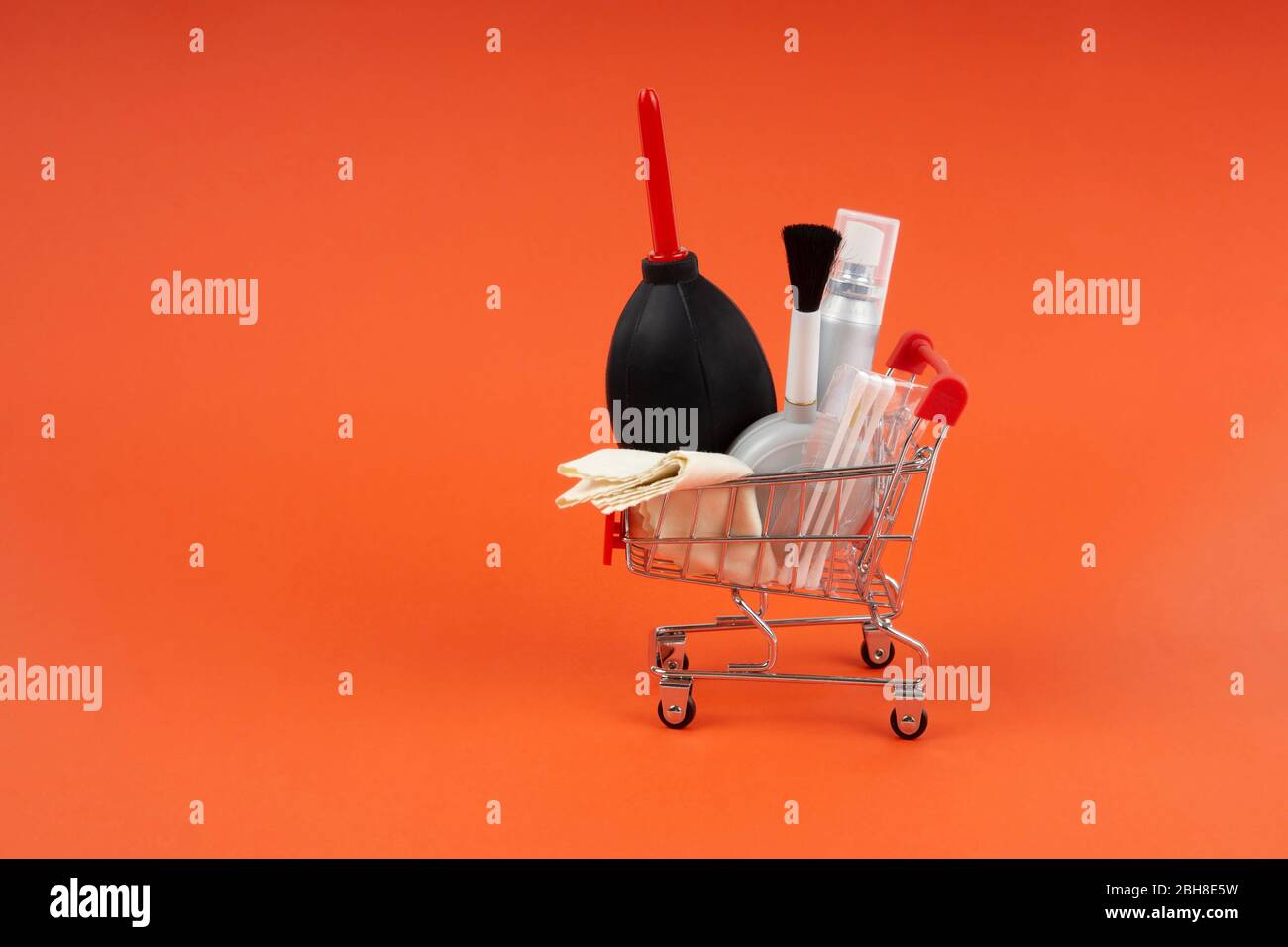 Miniature shopping cart carrying a lens and camera cleaning kit dust