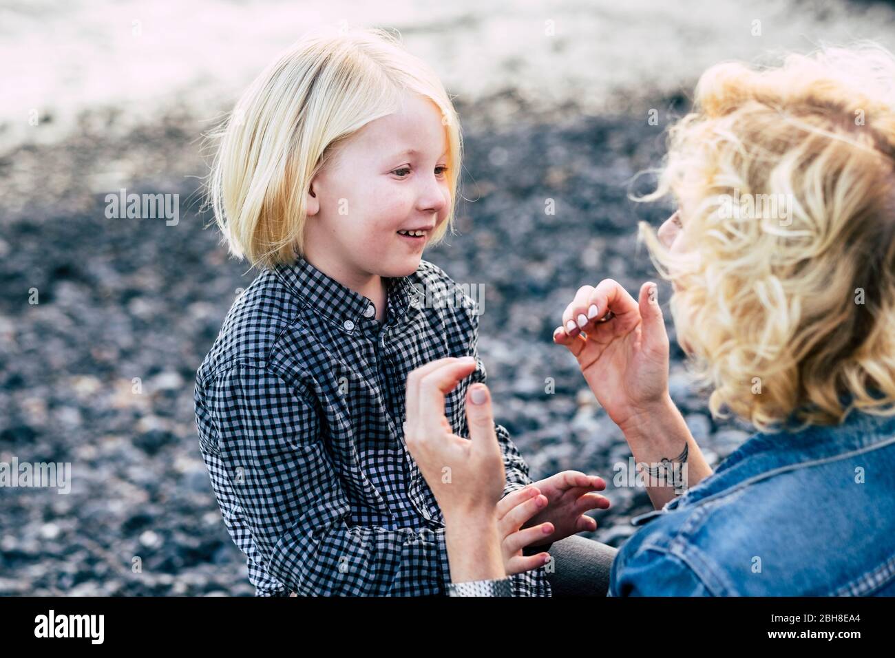 couple mother and son middle age and child play together outdoor with love and happiness - family concept with lonely lady and kid - love concept forever and grown up child - smile and laugh playing Stock Photo