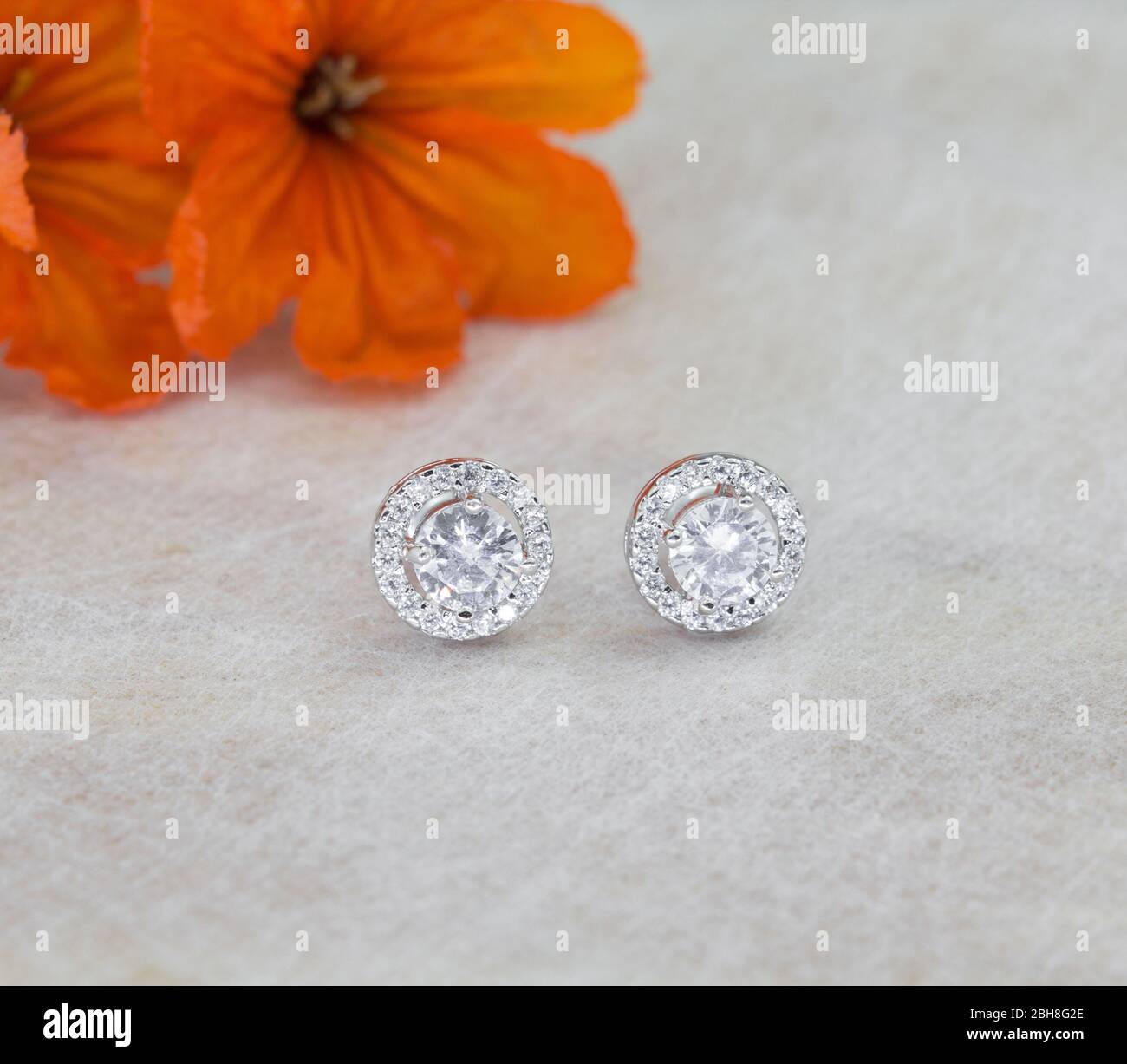 A pair of beautiful 925 sterling silver earrings with cubic zirconia isolated on gray background Stock Photo
