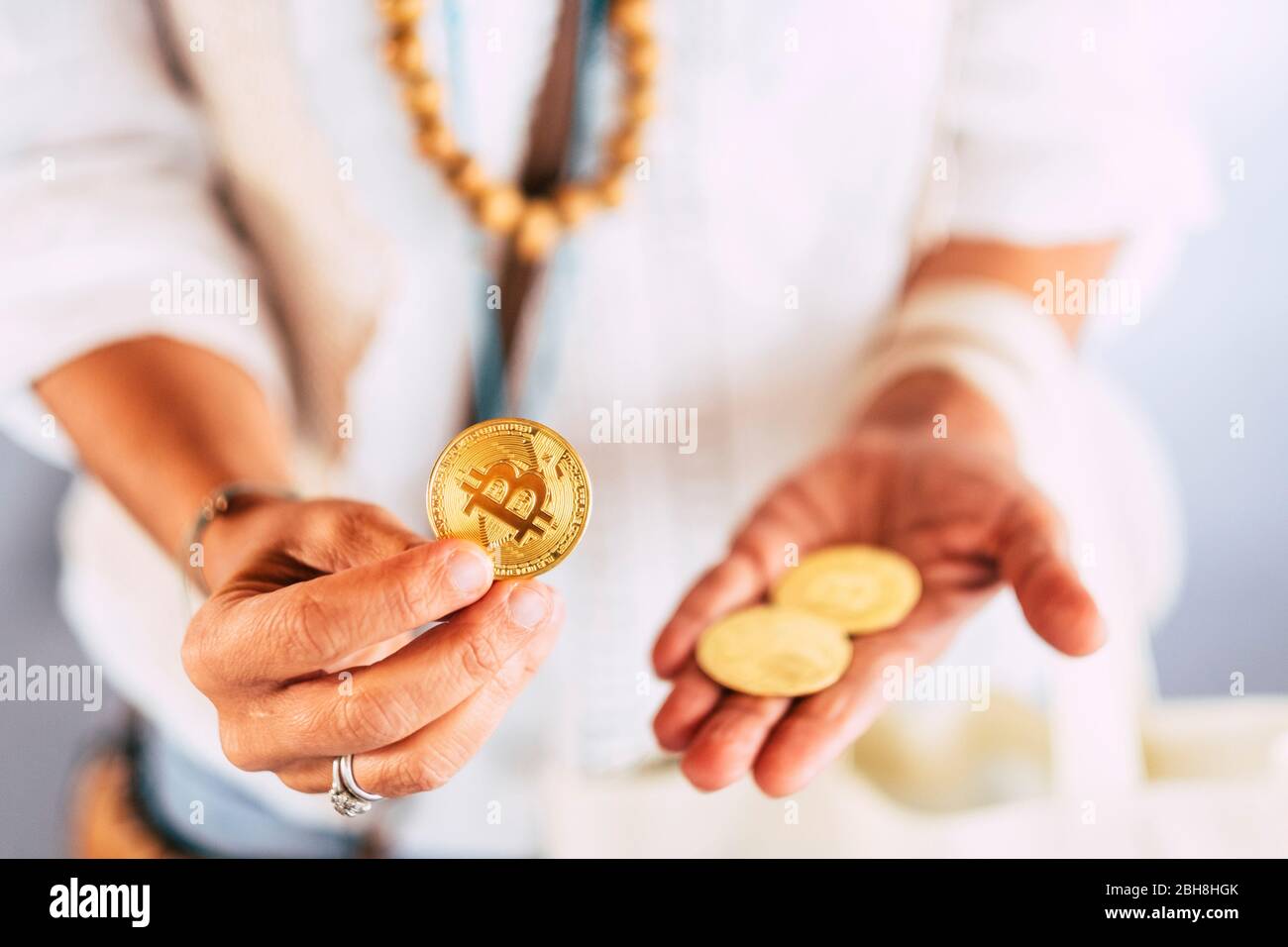 Middle age woman hands use and show gold bitcoin coin for new modern  technolgy virtual money