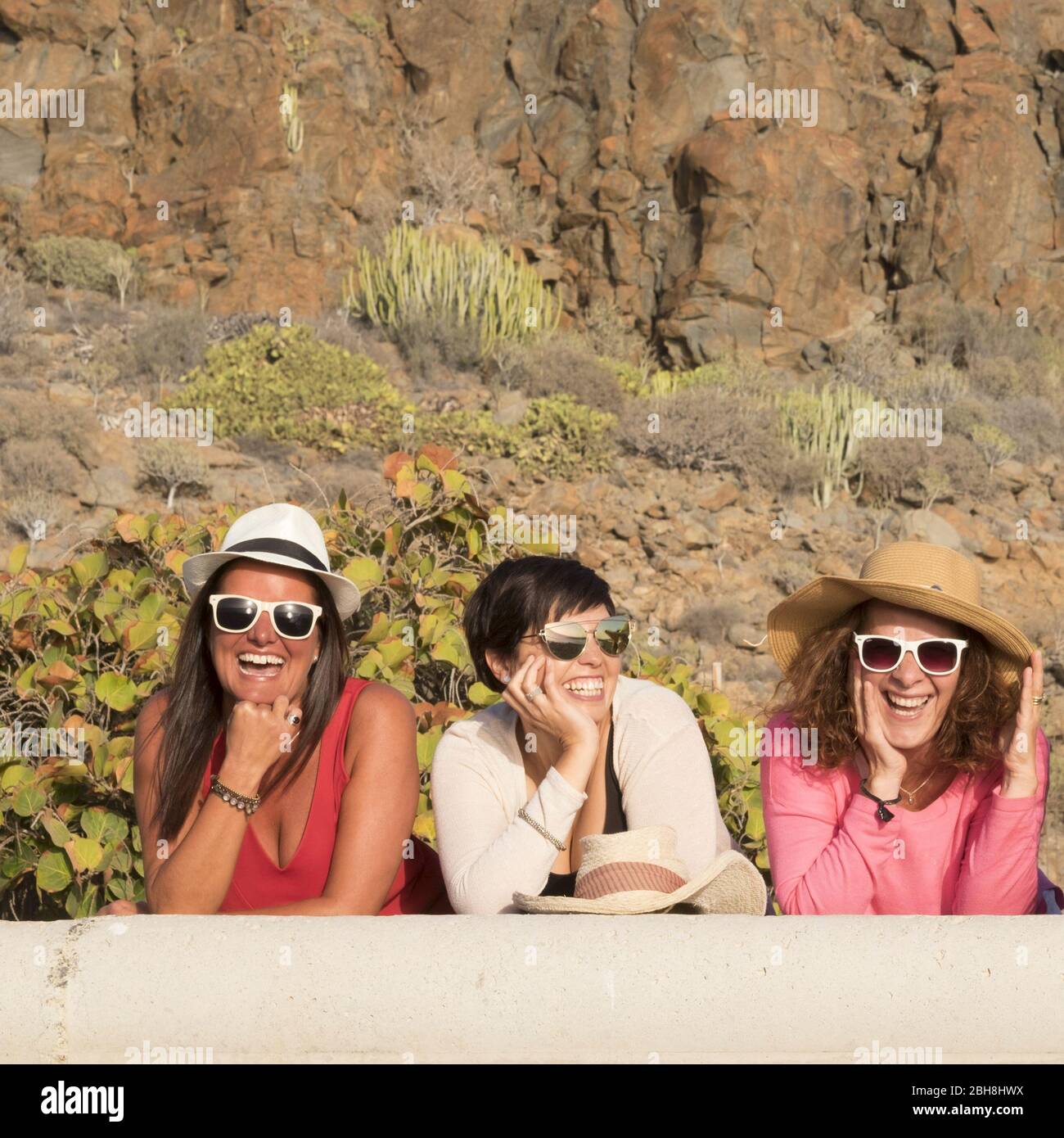 Happiness concept with three young friends women together with hats and sunglasses in summer day laughing and having fun - cheerful female people caucasian - summer and vacation Stock Photo