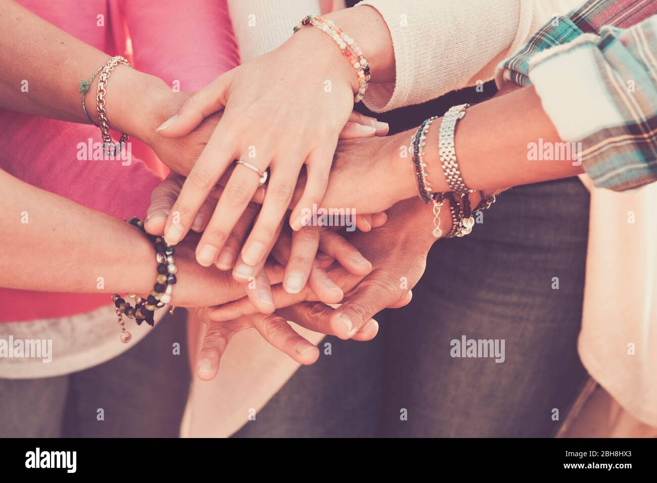 Teamwork and friendship together concept with hands put on hands - women power day for work and friends - caucasian people team in vintage filter colors Stock Photo