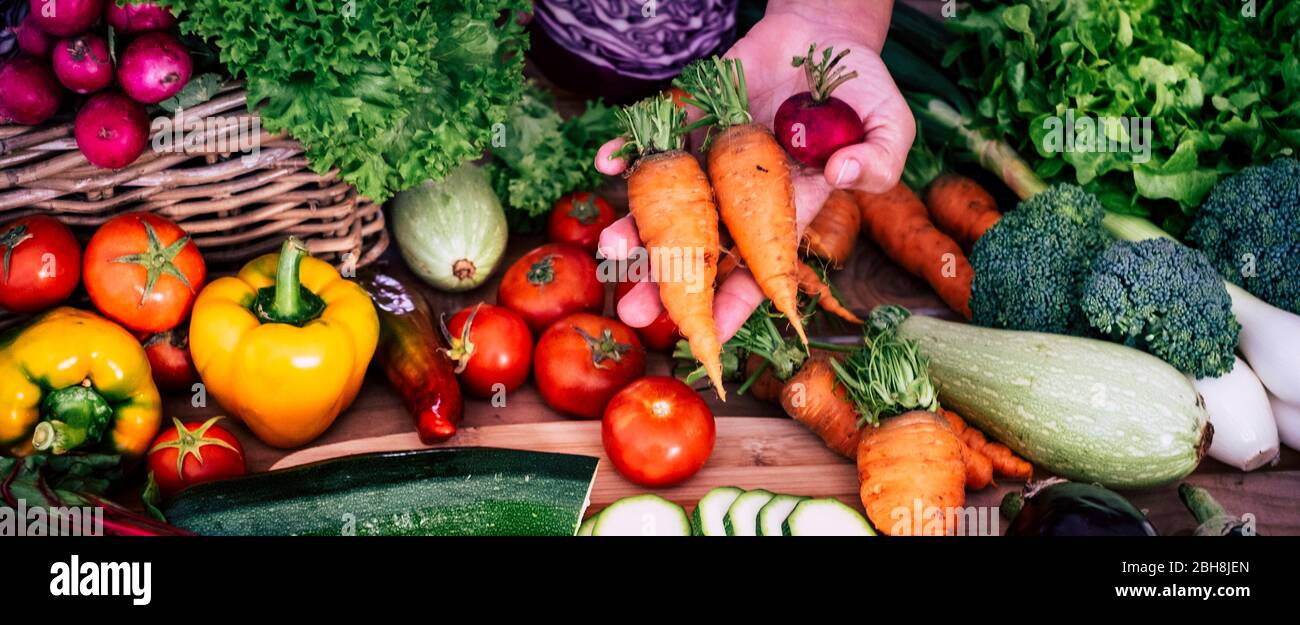 table full of fresh vegetables seasonal and farmer or seller or woman at home showed you some - mixed ingredients for healthy lifestyle vegetarian with a lot of vitamins and anti aged Stock Photo