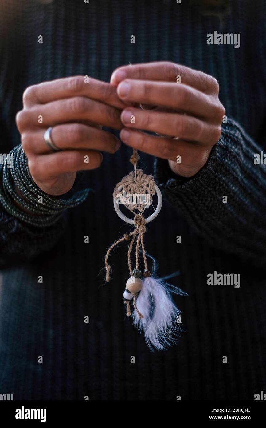 closeup of woman caucasian hands taking a hand made chic dreamcatcher indian culture for hope and love Stock Photo