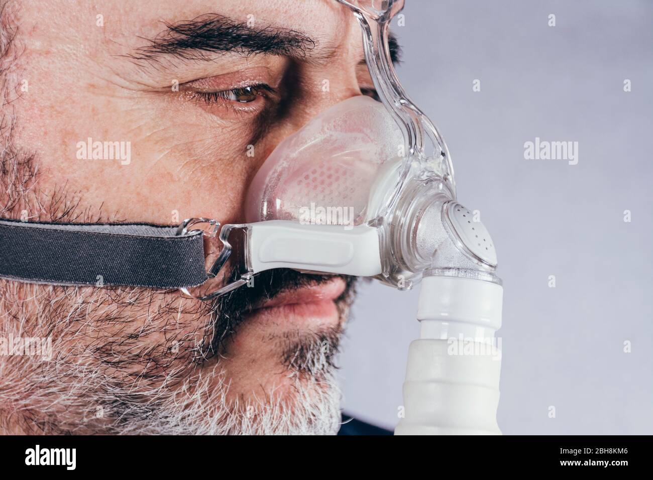 Senior man with respiratory mask for sleep disorders. Apnea. Medical