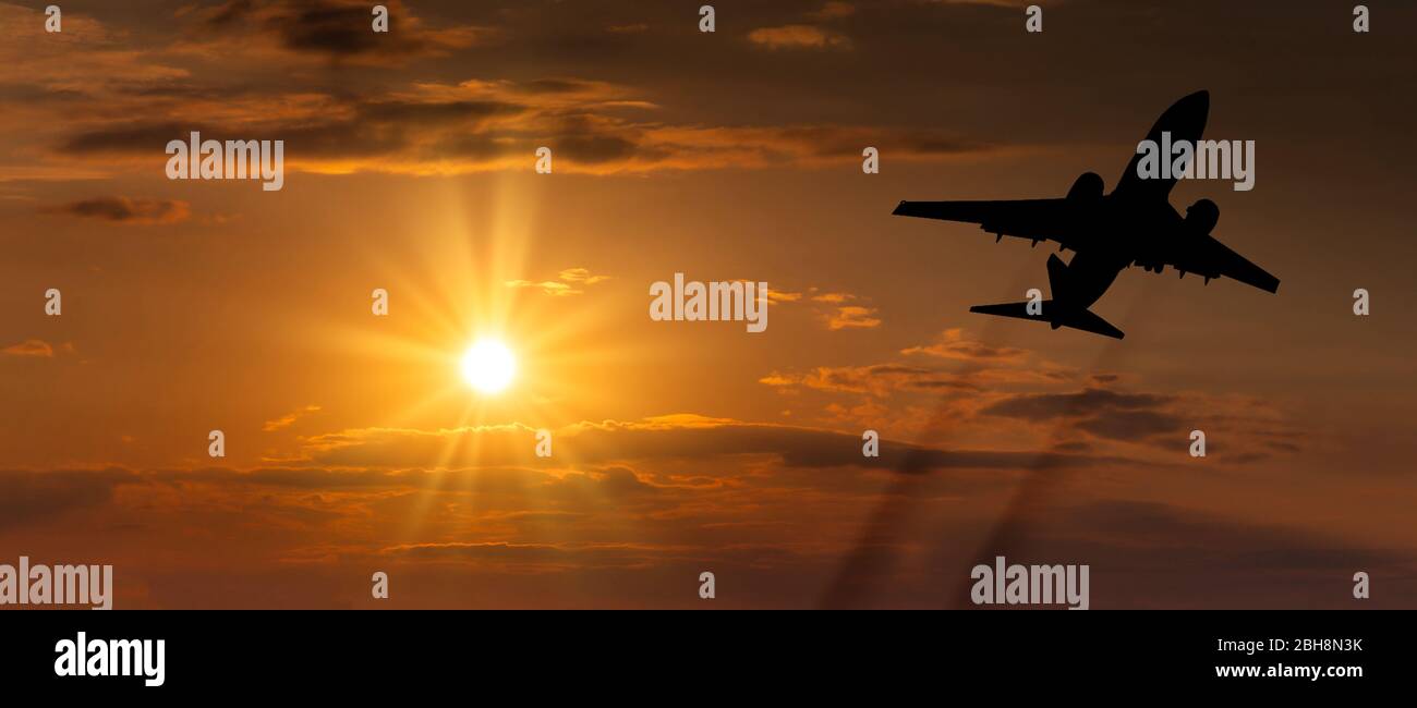 Airplane taking off at sunset. Silhouette of a big passenger or cargo aircraft, airline. Transportation Stock Photo