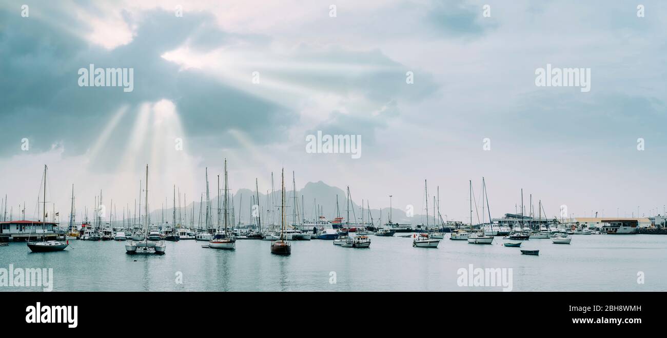 Sailboats and pleasure boats in the porto grande bay of the historic city Mindelo. Sunrays. Stock Photo