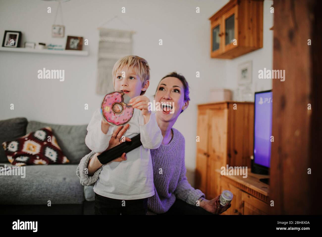 Mutter und Sohn beim gemeinsamen Videospiel im Wohnzimmer Stock Photo