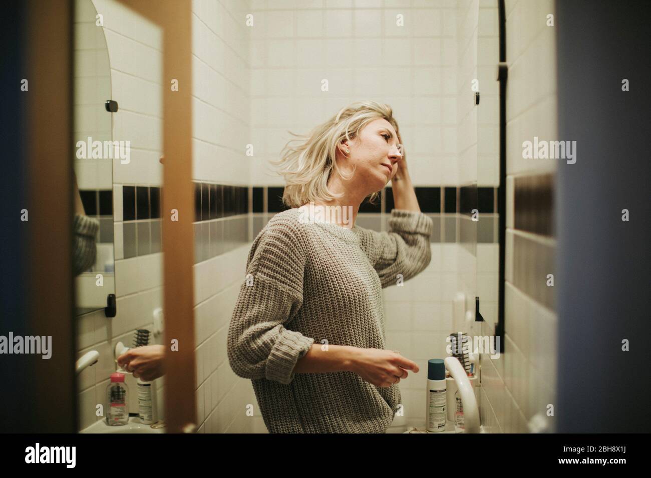 Frau im Badezimmer, betrachtet kritisch ihr Gesicht Stock Photo - Alamy
