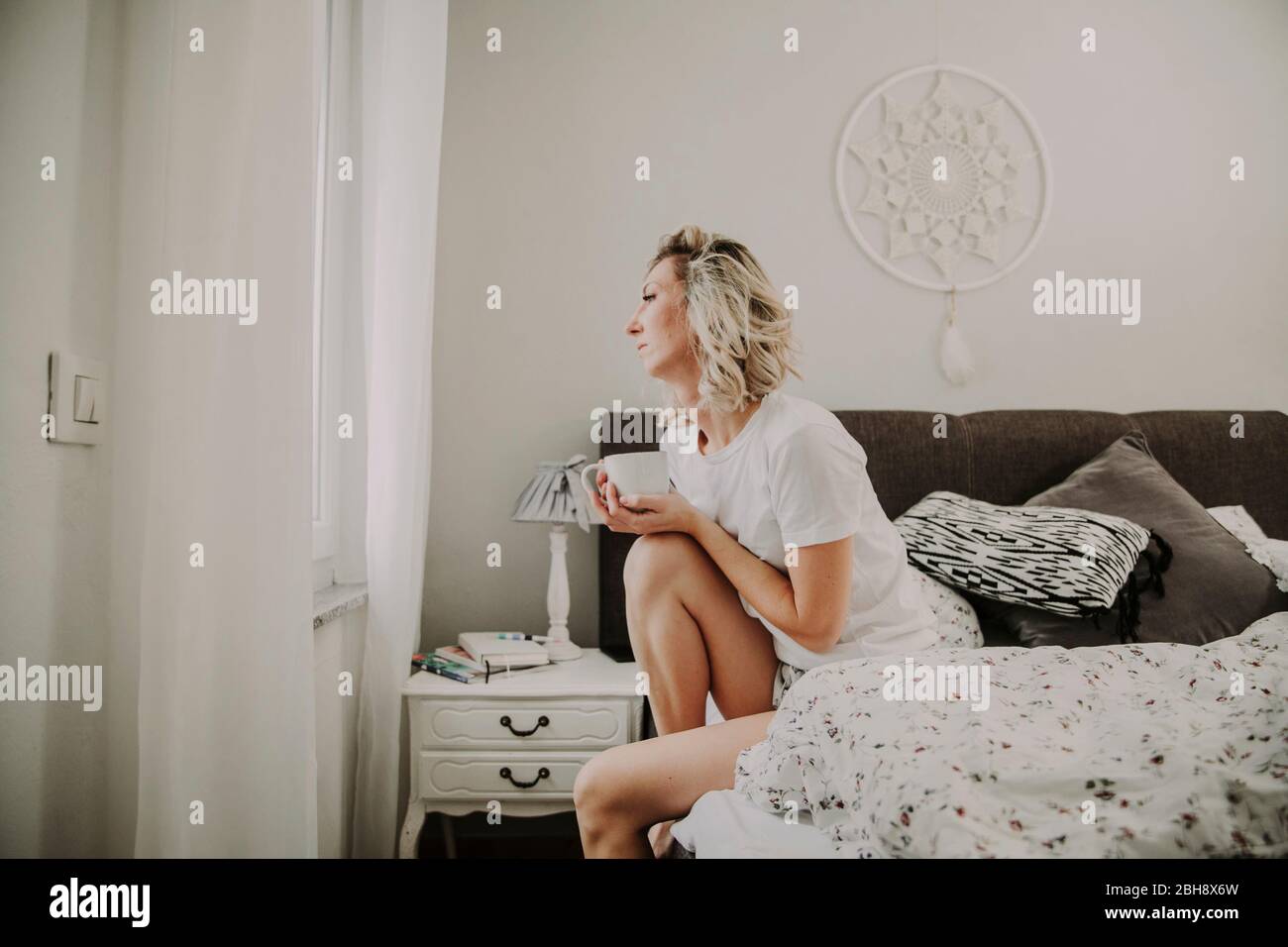 Frau mit Kaffeetasse im Bett Stock Photo