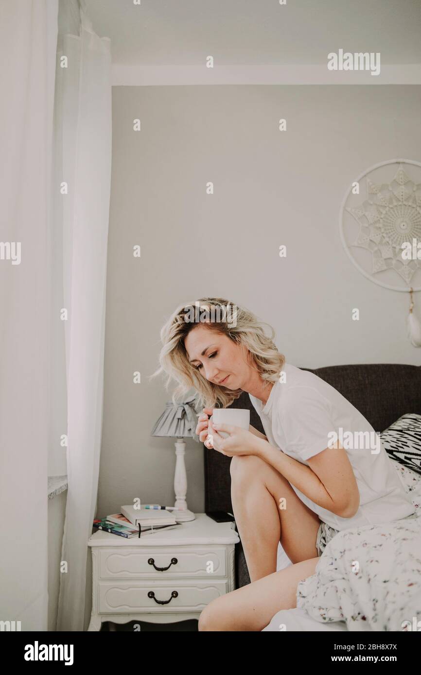 Frau mit Kaffeetasse im Bett Stock Photo