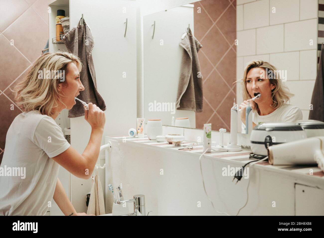 Frau beim Zähne putzen im Bad Stock Photo