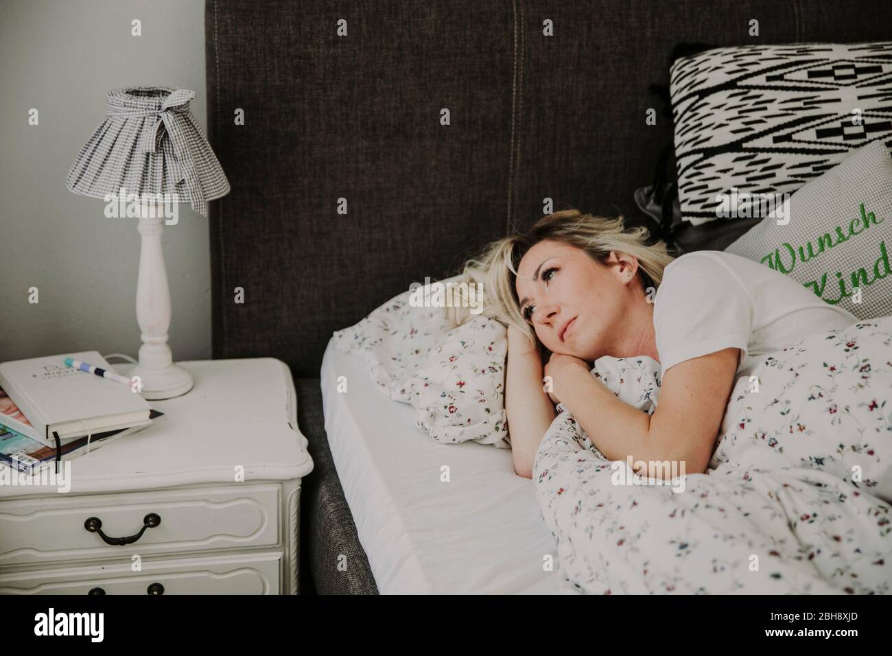 Frau liegt nachdenklich im Bett Stock Photo