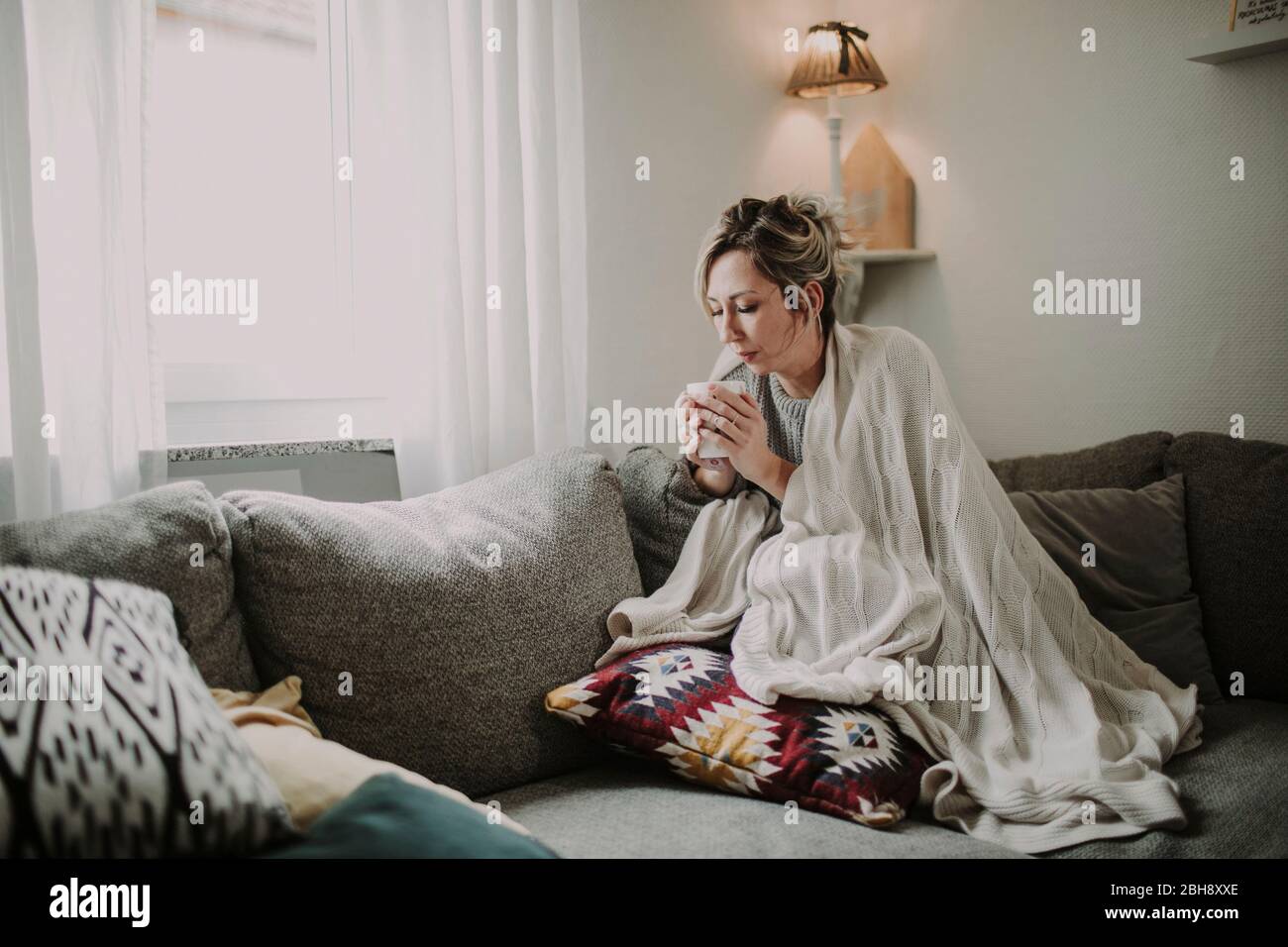 Frau mit Teetasse auf der Couch Stock Photo