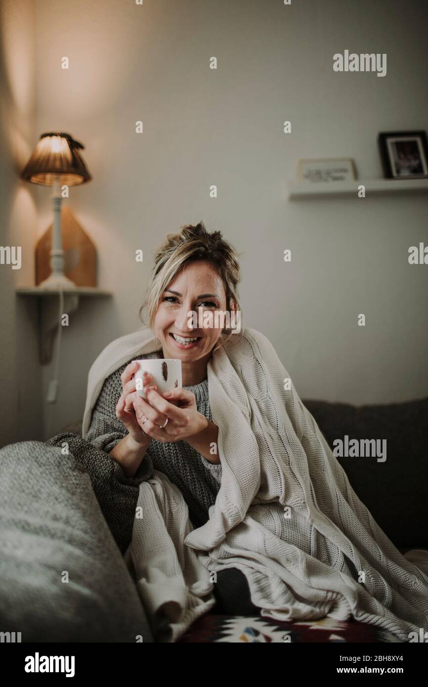 Frau mit Teetasse auf der Couch Stock Photo