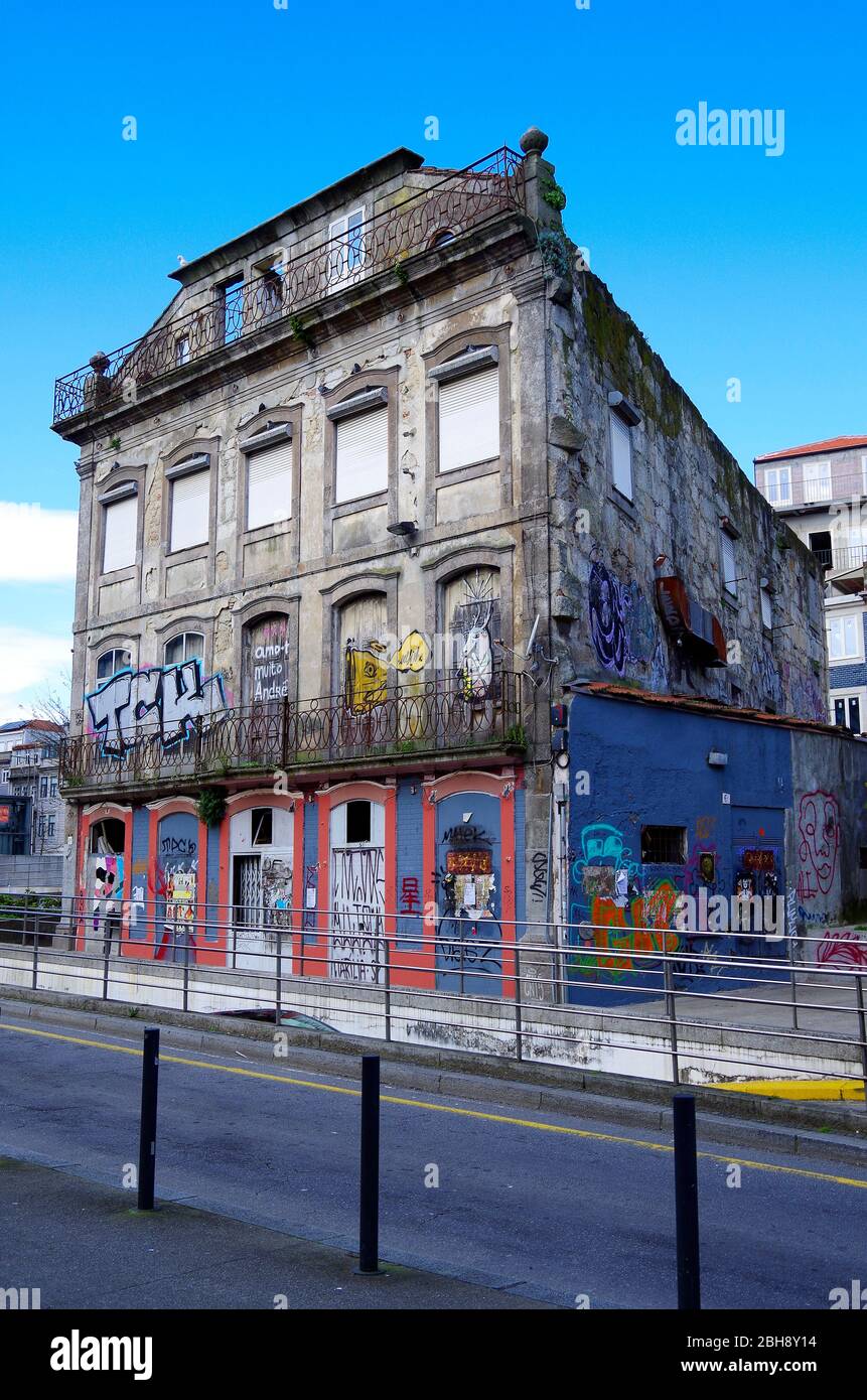 A once elegant four-storey building in downtown Porto, Portugal, now sealed up, and covered in grafitti awaiting demolition or perhaps refurbishment Stock Photo
