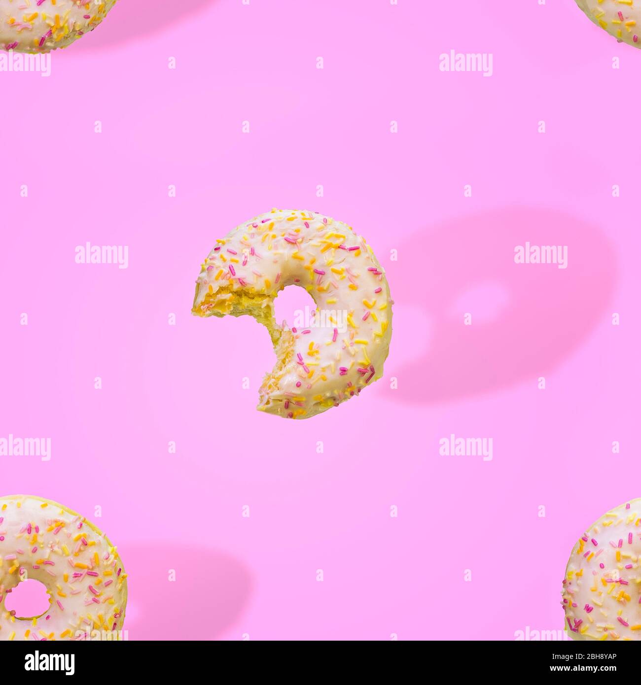 donuts pattern bitten bake sweet dessert pink background Stock Photo