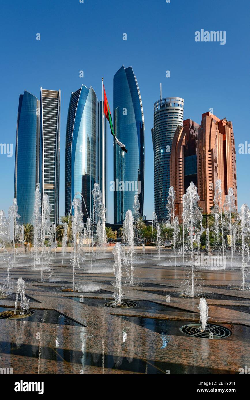 Blick durch Wasserspiele auf den aus 5 Türmen bestehenden Gebäudekomplex Etihad Towers in Abu Dhabi als Wahrzeichen dieser Stadt Stock Photo
