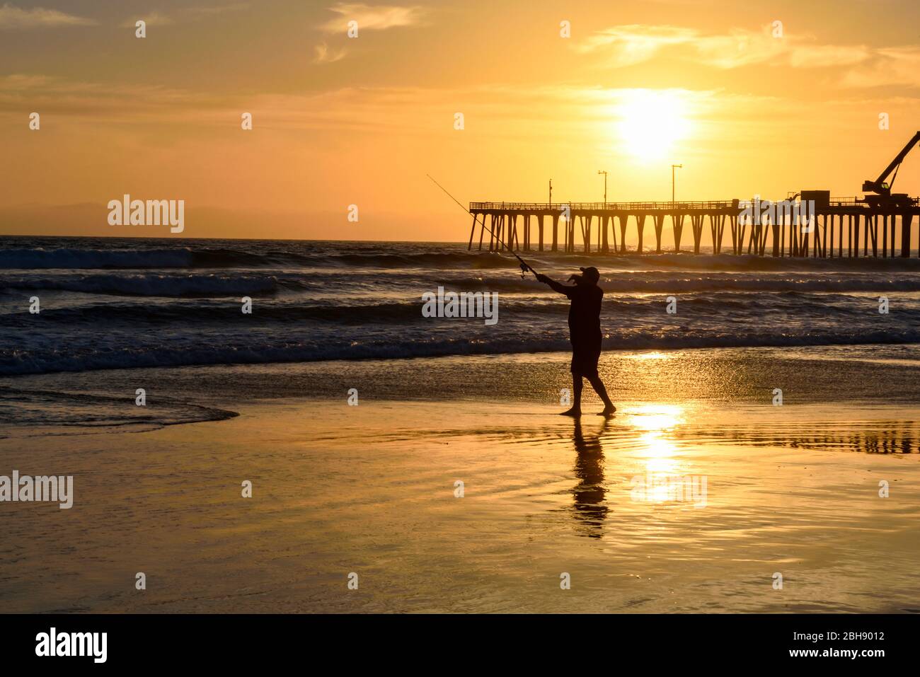 Angler am Strand von Santa Cruz an der Westküste Kaliforniens mit Pier im Hintergrund, Silhouette, Sonnenuntergang Stock Photo