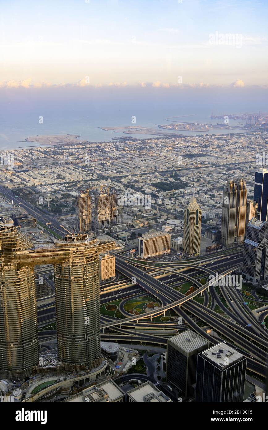 Dubai Downtown von oben, gesehen von der Aussichtsplattform des höchsten Hauses der Welt, dem Burj Khalifa bei Sonnenaufgang mit Kreuzung der Sheikh Zayed Road als wichtigste Schnellstraße Dubais Stock Photo