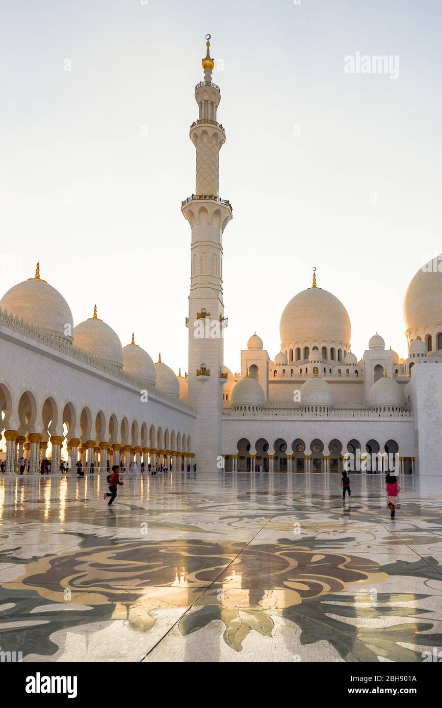 Innenbereich der Scheich Zayid Moschee in Abu Dhabi mit spielenden Kindern bei Sonnenuntergang, Erwachsenen ist das Betreten dieses Bereiches verboten Stock Photo