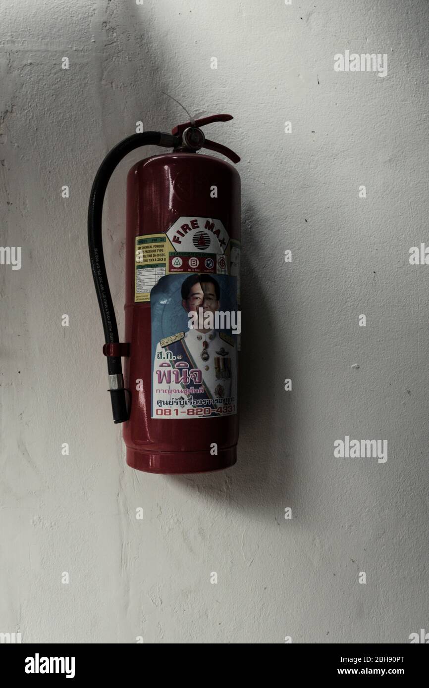 Fire extinguisher on the ribbon with the portrait of a Thai dignitary on the corpus Stock Photo