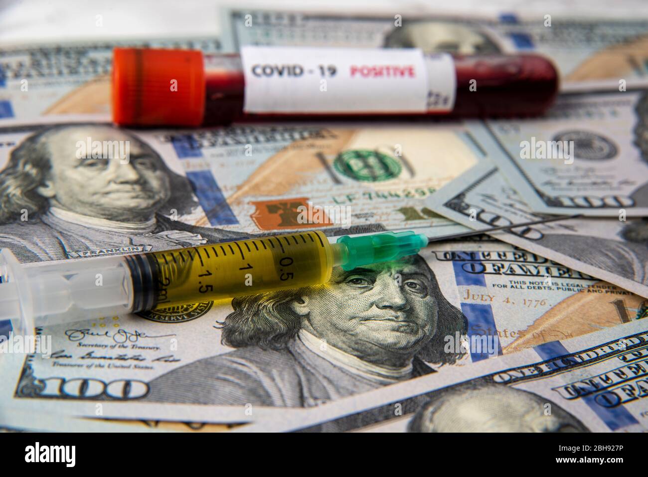 coronavirus vaccine and covid19 blood sample on dollars. corona economic Stock Photo