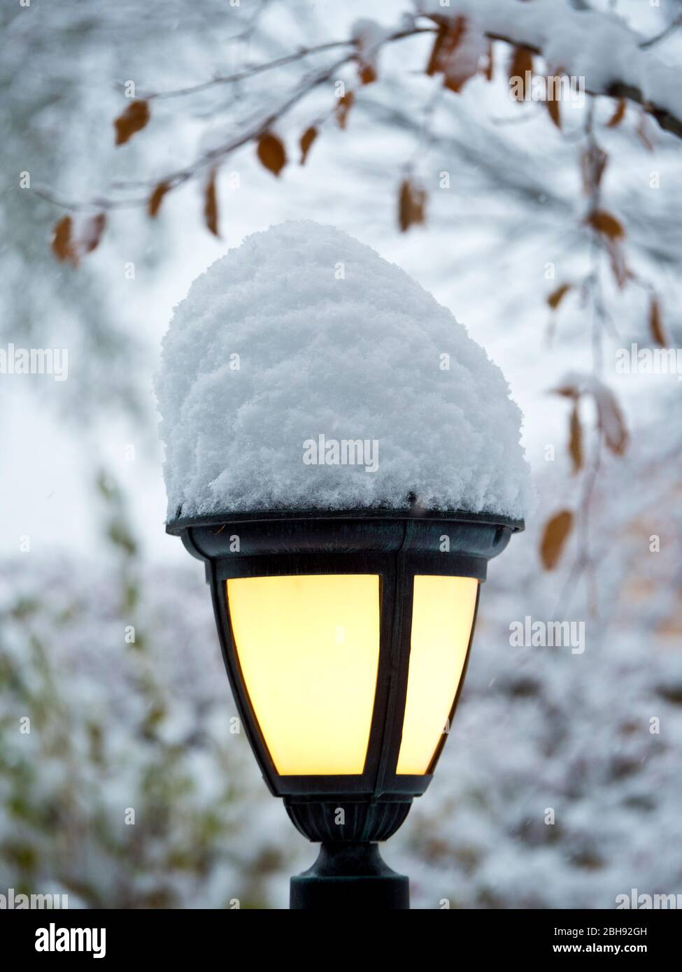 wrought iron lamp, outdoors, winter, snow, yellow, cold/warm, welcoming, light, lantern, beacon, reliable, security, European Stock Photo