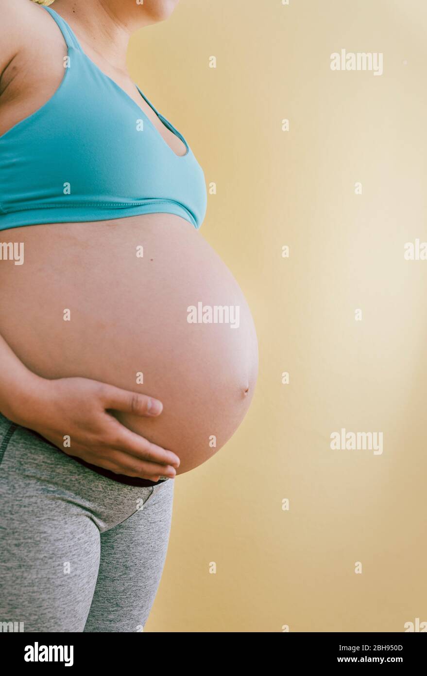 Look-up: Pregnant Woman Holding the Heavy Tummy Stock Photo