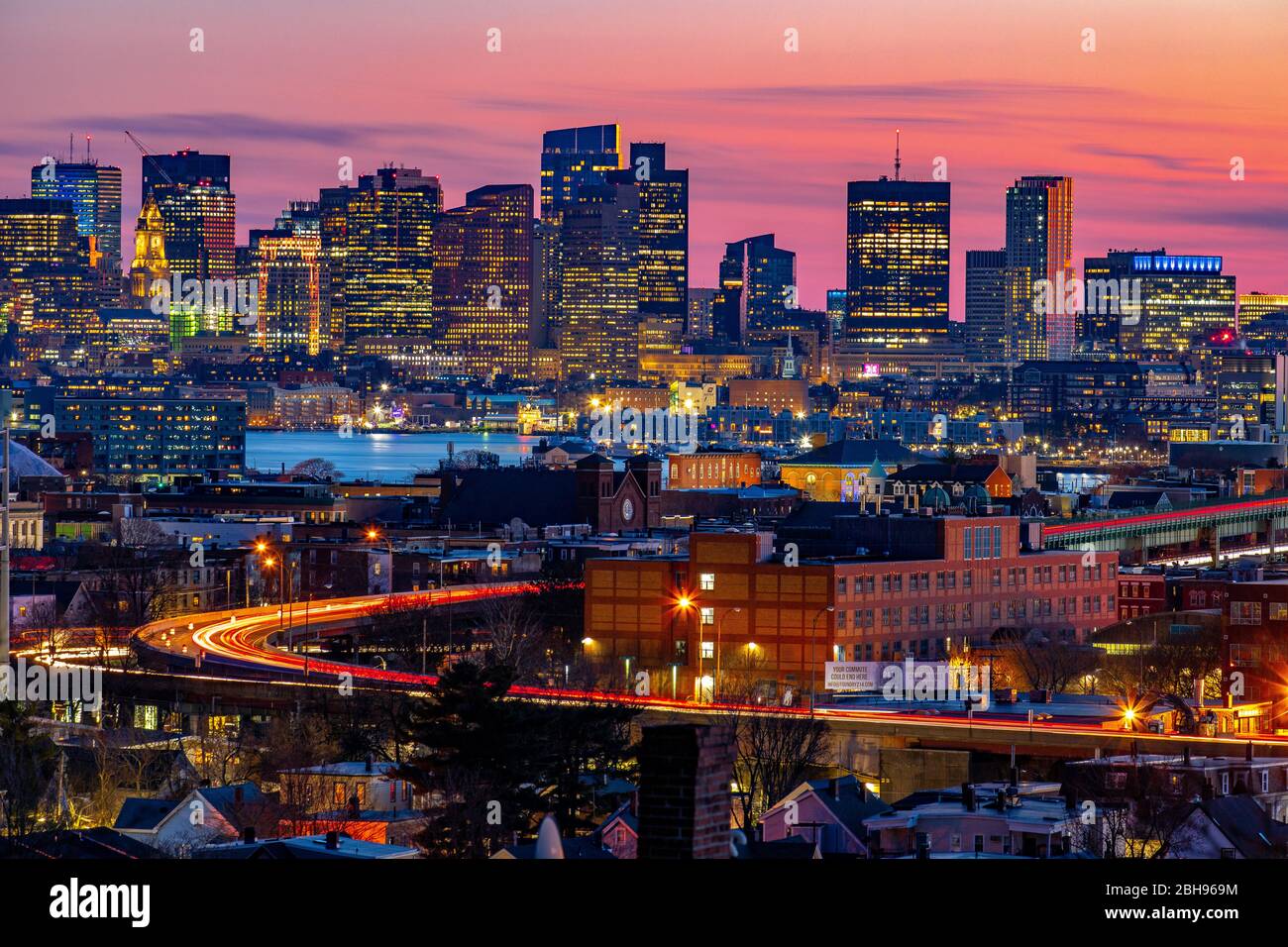 Boston city buildings and light trails under a pink sunset sky Stock
