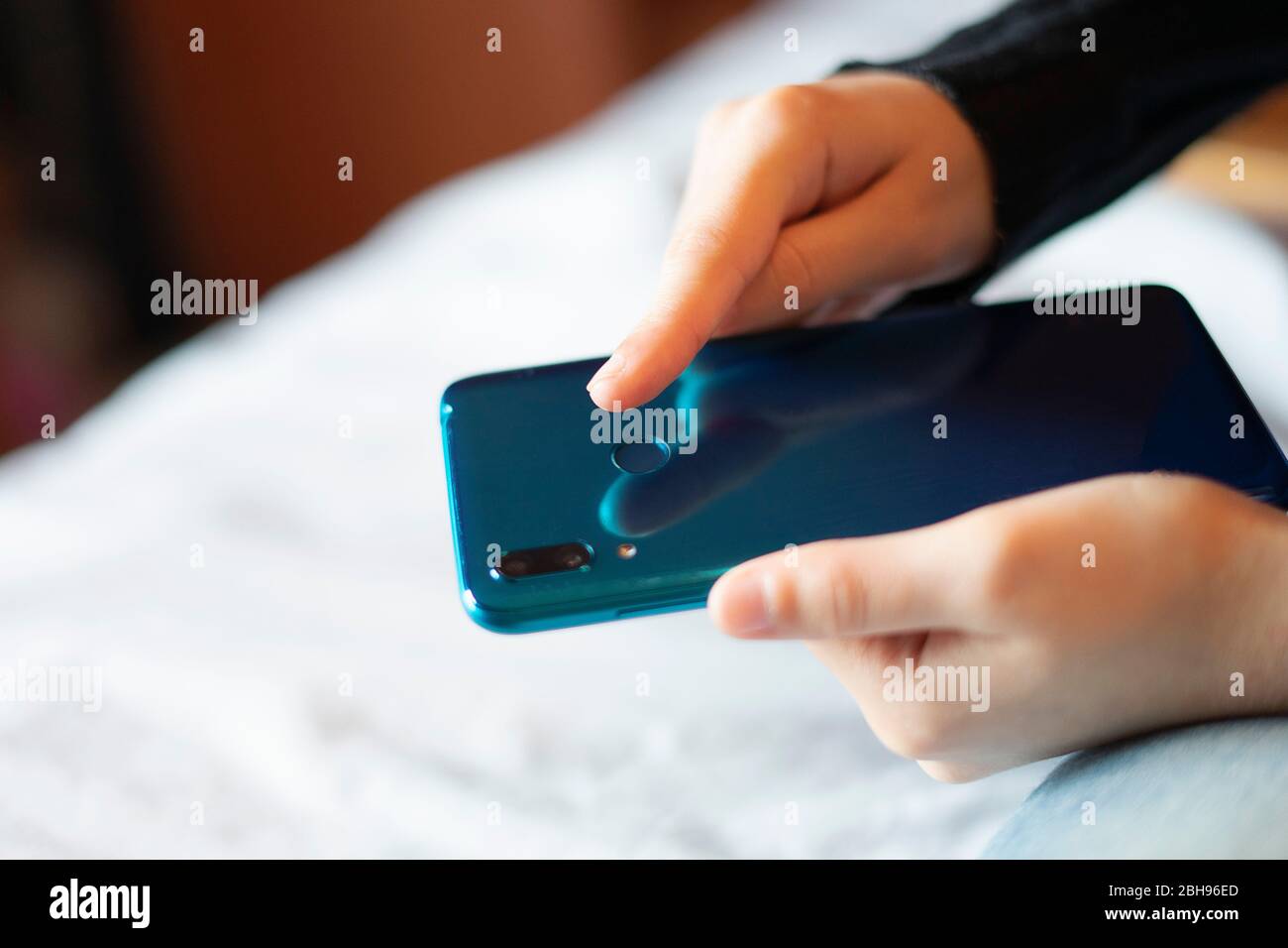 Hand unlocking the mobile with fingerprint. Stock Photo