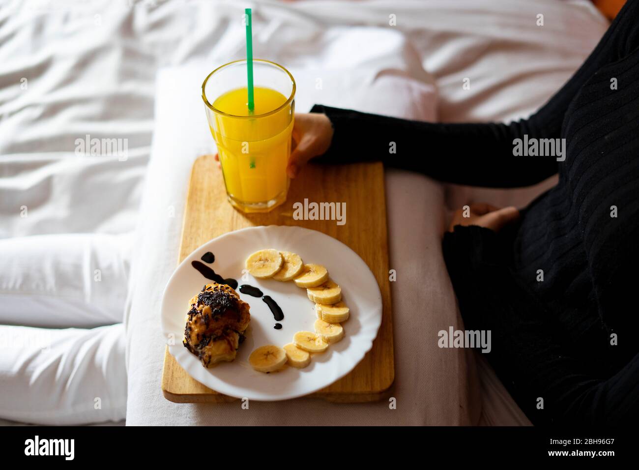 Woman having breakfast in bed in the morning. Stock Photo