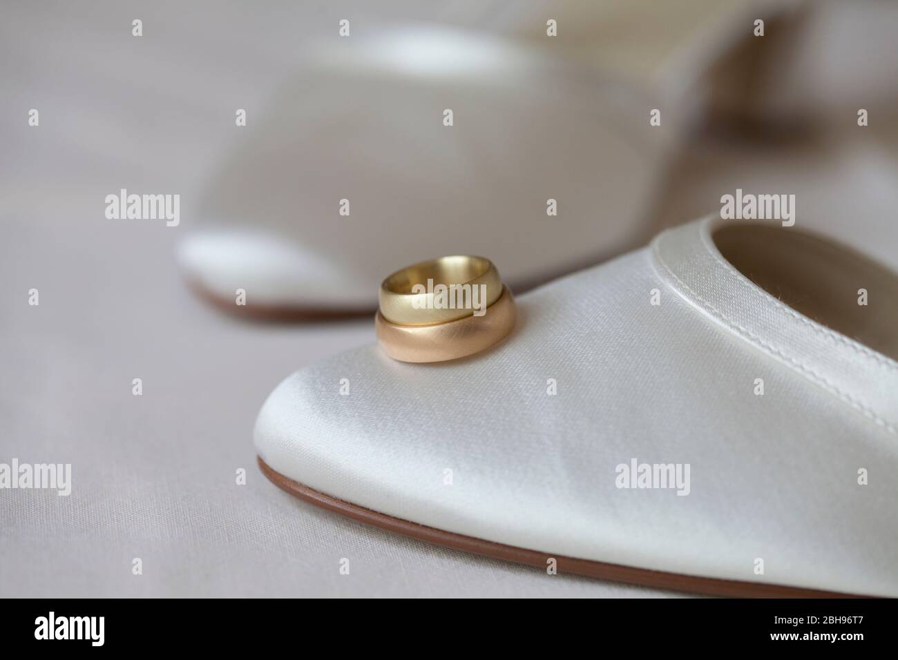 Gold and red gold wedding rings on white bridal shoe hi-res stock ...