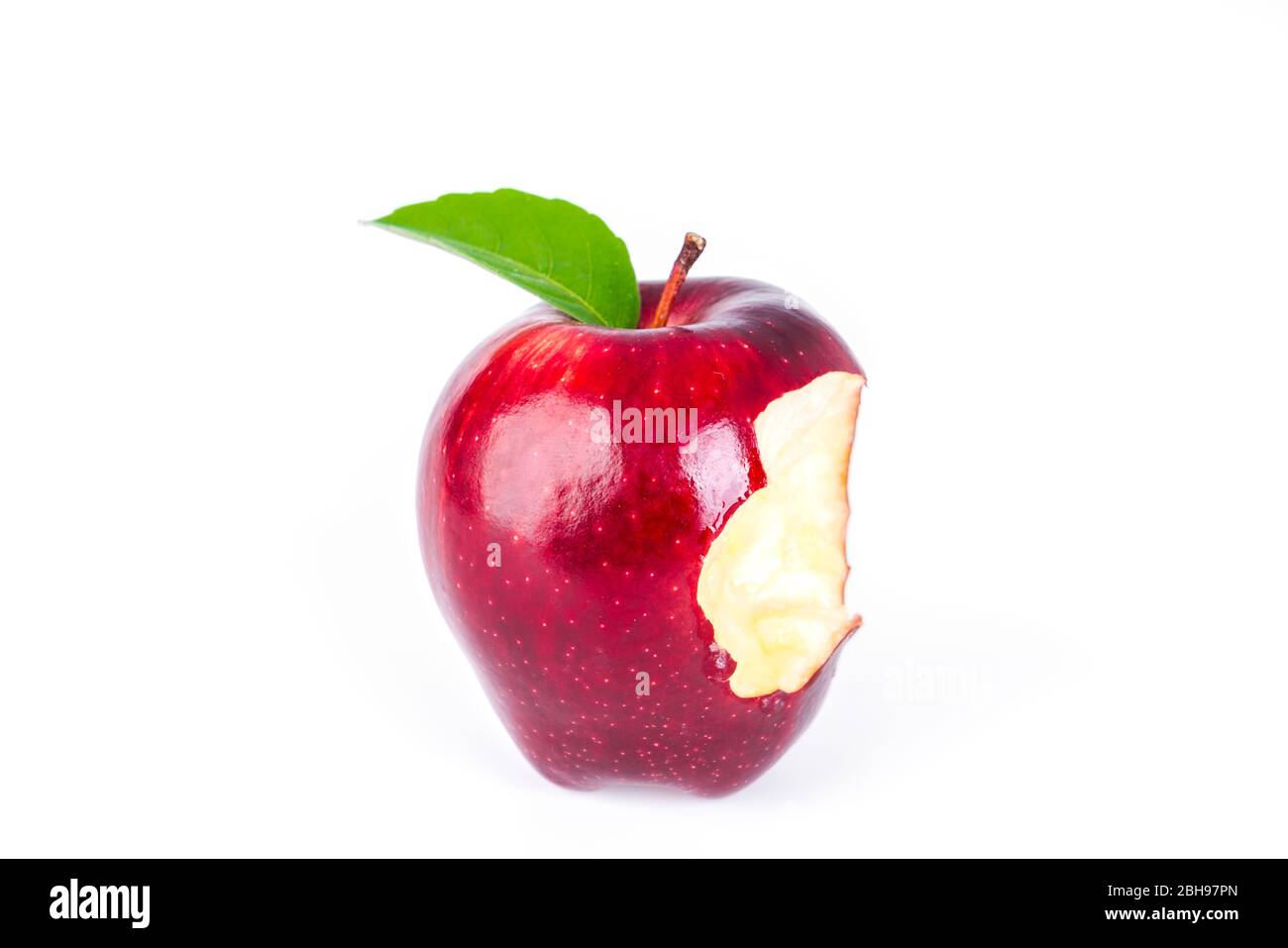 Red apple with green leaf and missing a bite . Stock Photo
