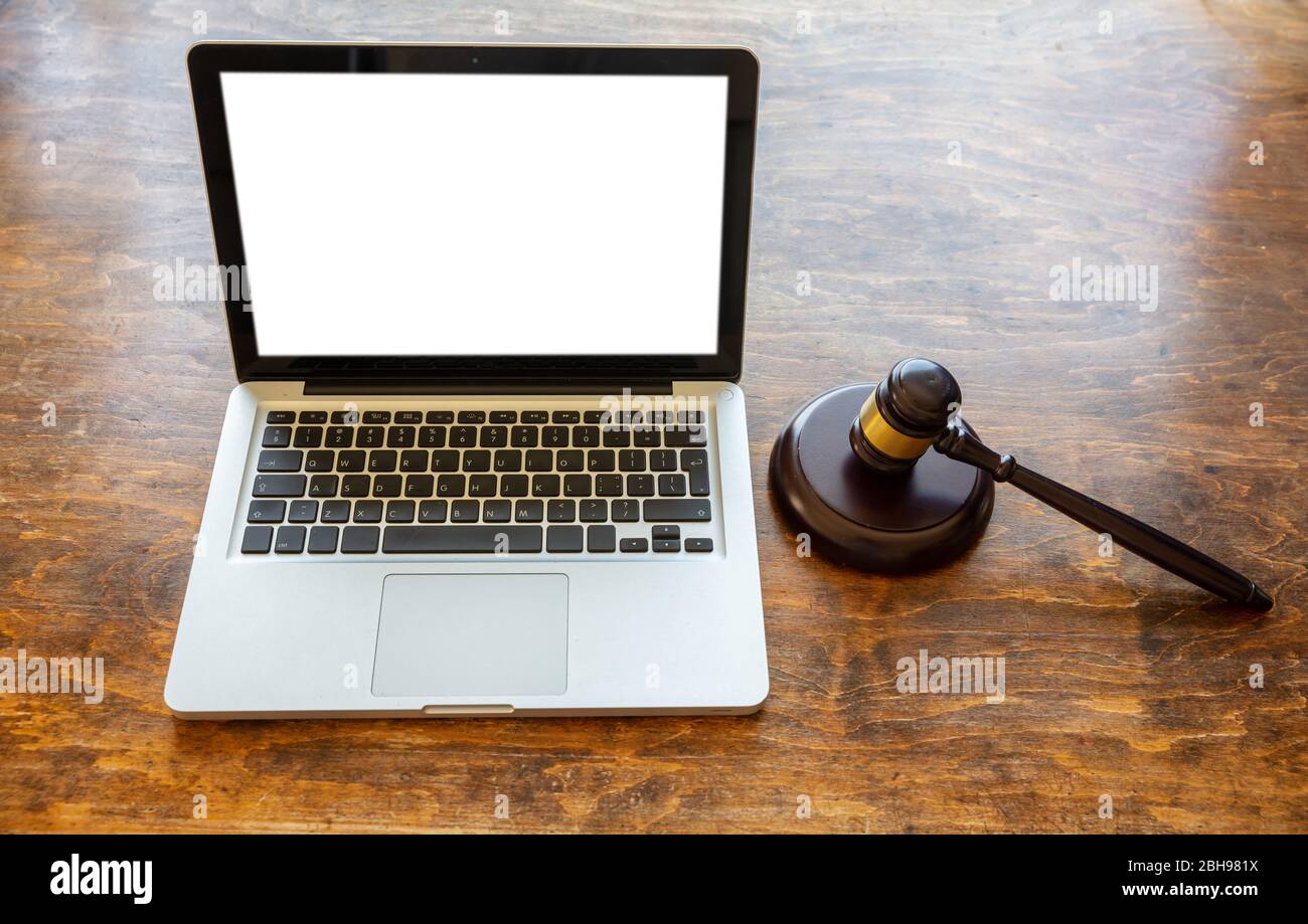 Auction judge gavel and a blank white screen open laptop, wooden office desk background. Online auction, legal decisions concept Stock Photo