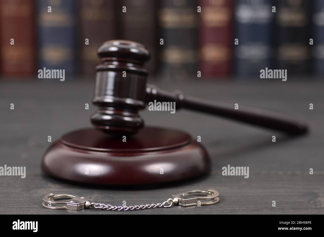 Law and Justice, Legality concept, Judge Gavel and Handcuffs on a black wooden background. Stock Photo