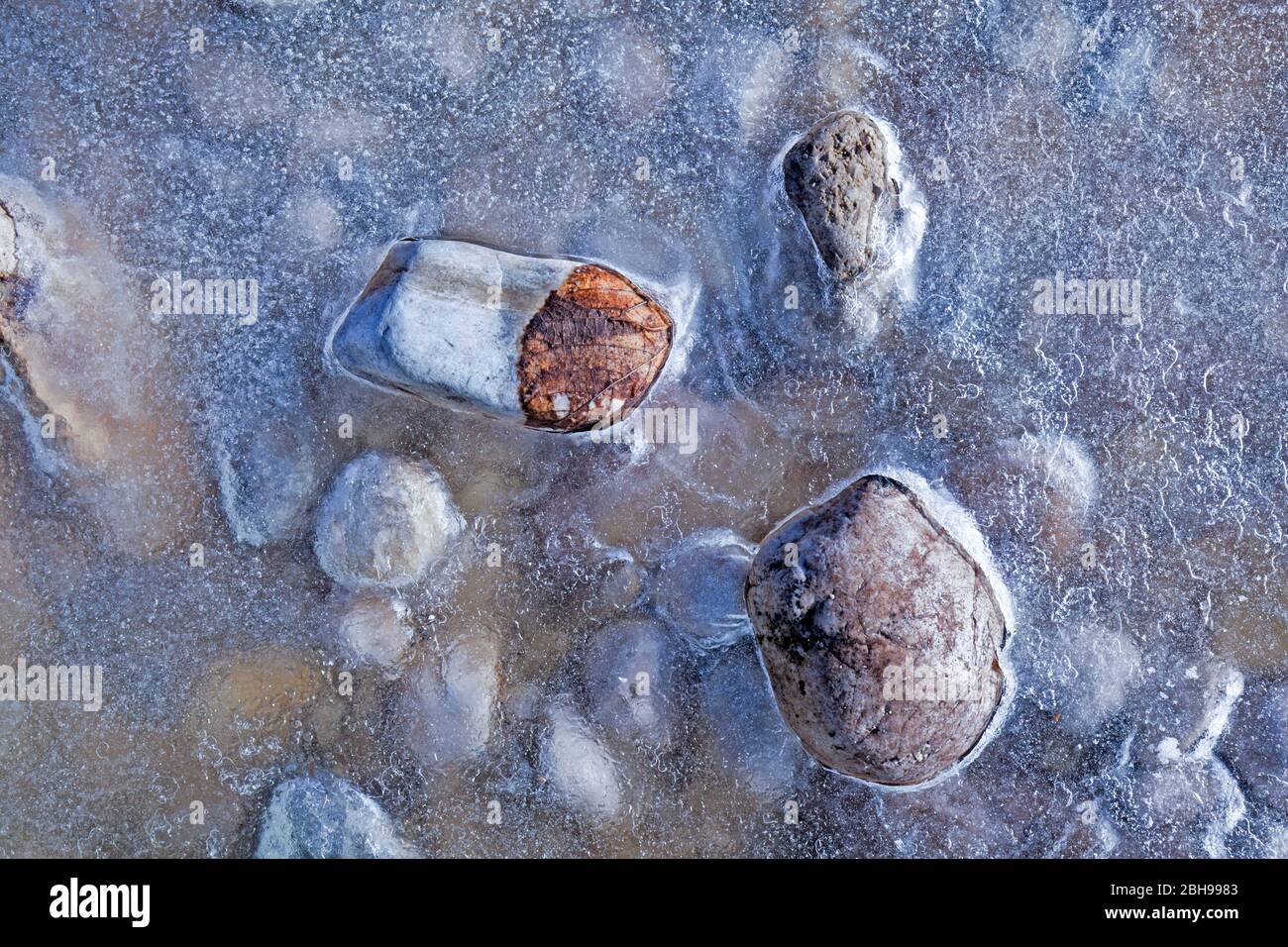 Frozen stones in the riverbed Stock Photo