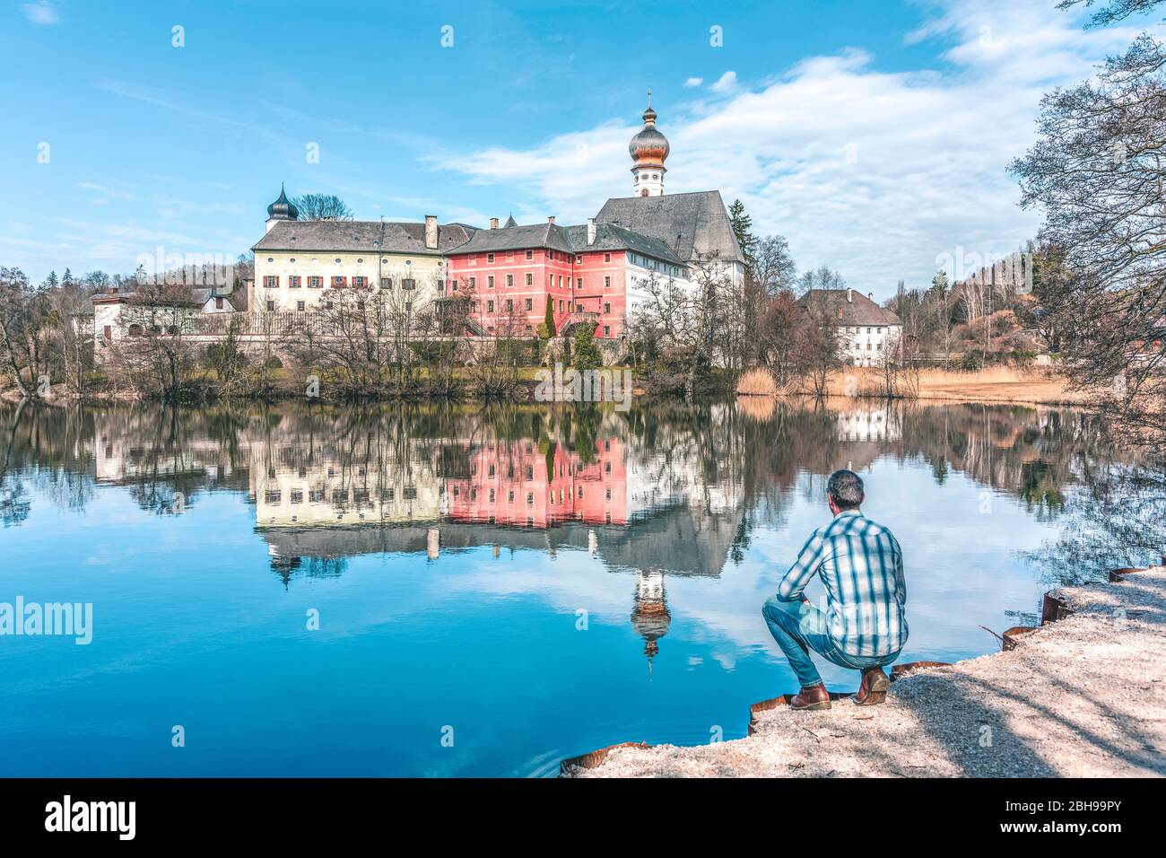 One man tourist looking the Höglwörth abbey of St Peter and Paul, Aaugustinian monastery near Anger, Rupertiwinkel, Upper Bavaria, Germany Stock Photo