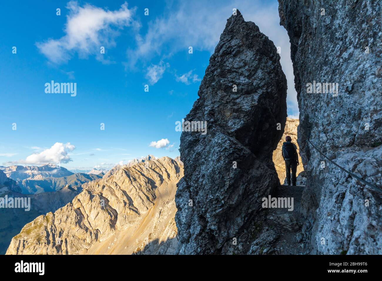 A hiker at the narrowest point of the Bepi Zac High Trail, Costabella Ridge, Marmolada group, Dolomites, Fassa Valley, Trento province, Trentino-Alto Adige, Italy Stock Photo