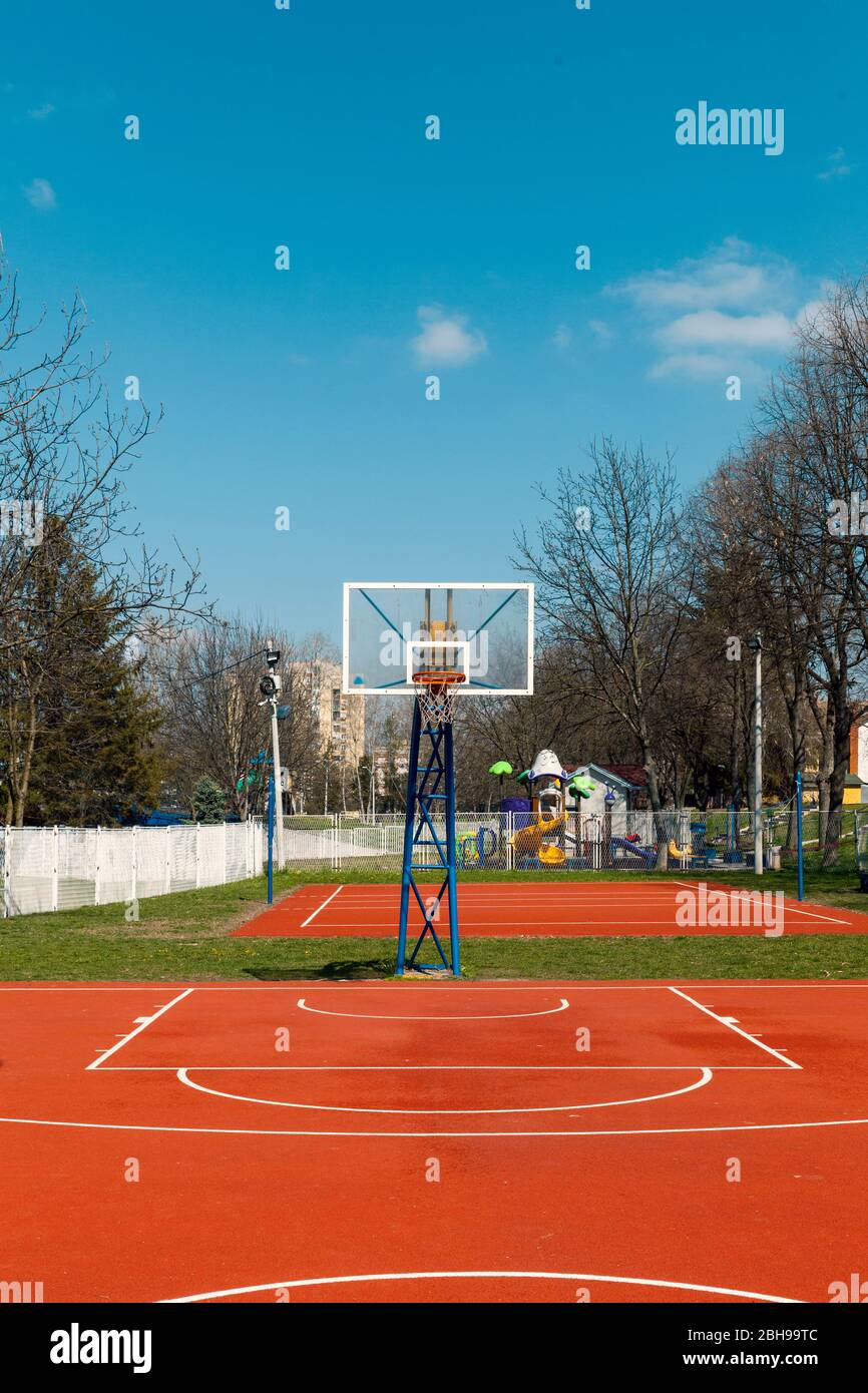 open basketball court with red playground in the park Stock Photo - Alamy