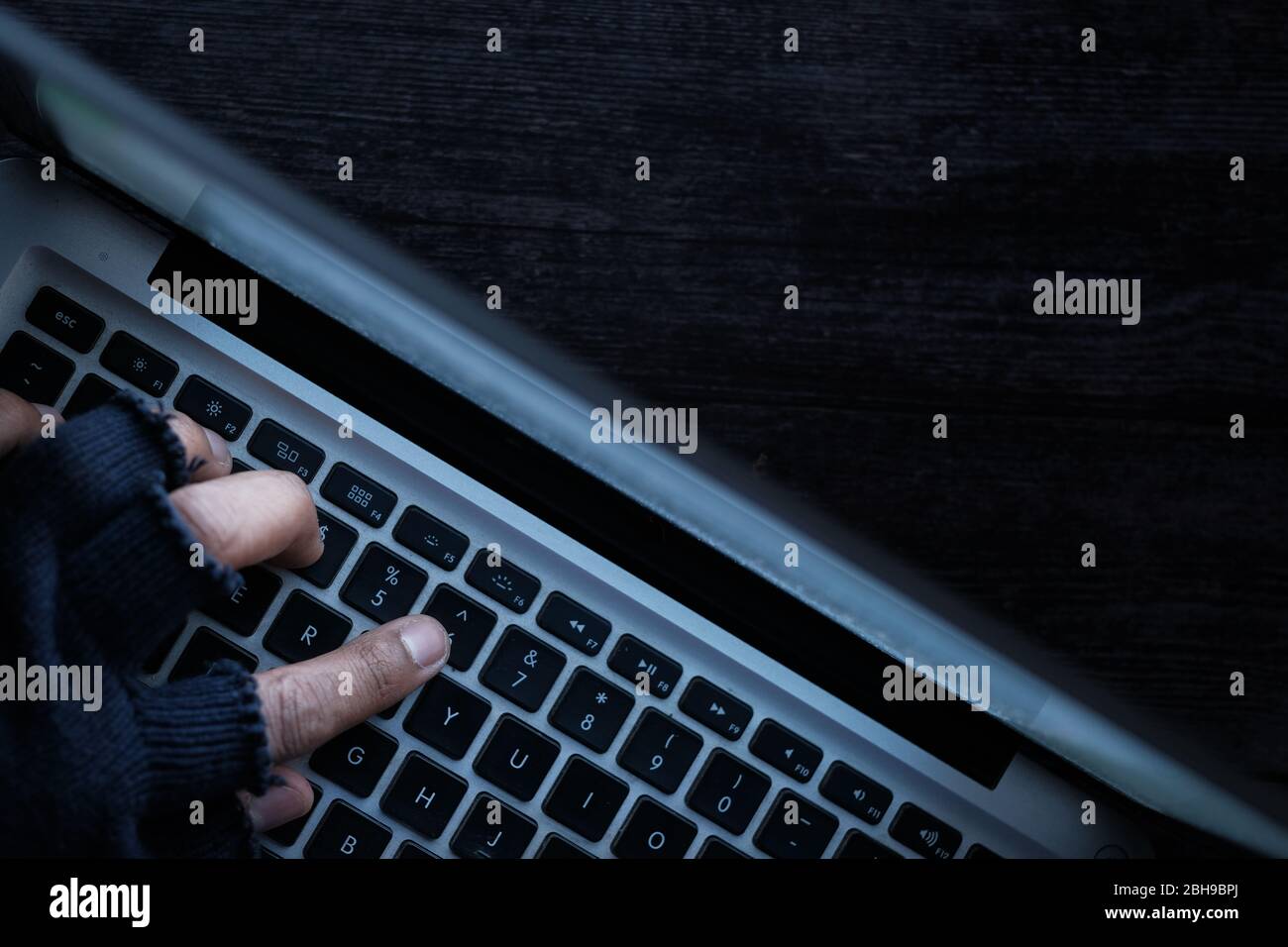 hacker hand stealing data from laptop at night  Stock Photo